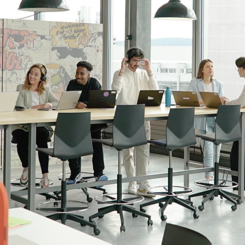 JobCloud Mitarbeitende sitzen an einem langen Tisch und haben ein Meeting.